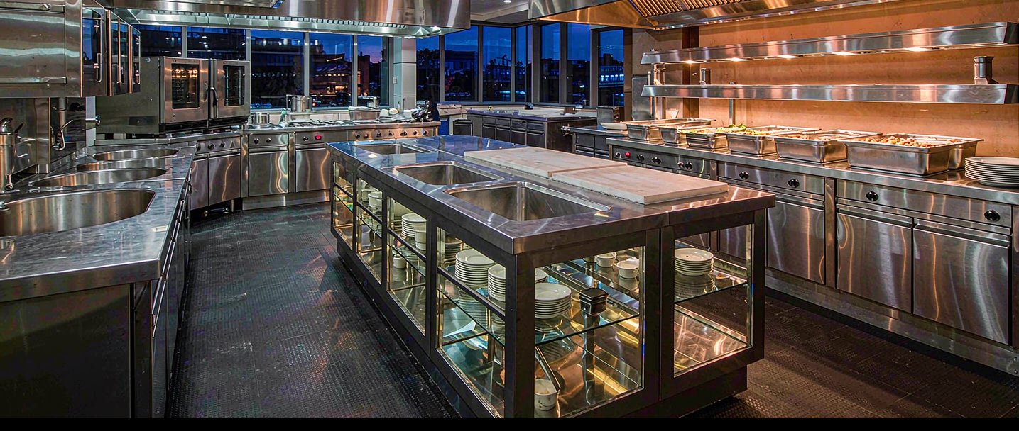 Hotel kitchen at night with stainless steel cooking suite and buffet line